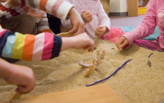 children's hands in sand